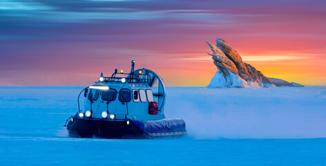 Hovercraft rides on Lake Baikal ice at sunset - Ogoy island on winter Baikal lake with transparent...