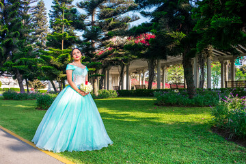 Beautiful young woman dressed in a princess costume in the middle of a park with trees
