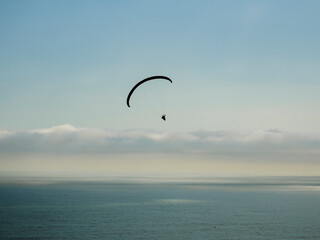 Silueta de vuelo en parapente sobre el océano pacifico, Perú, Sudamérica