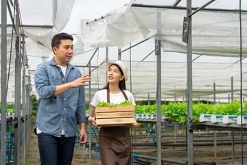 An Asian expert in hydroponic gardening is instructing women in proper irrigation and maintenance.