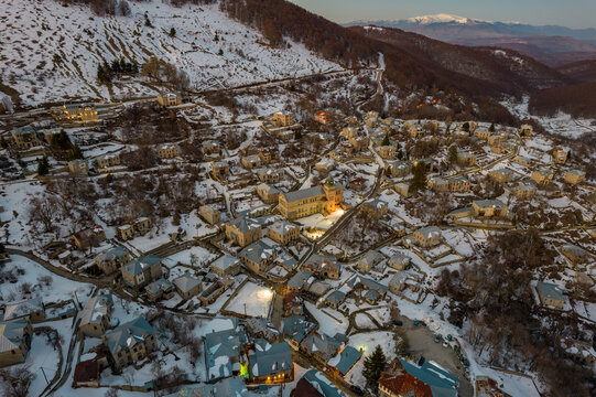 Aerial view of traditional architecture  with  stone buildings and the famous local school with a label in front. tranlation Nikios(name ) school in the snowy village of Nymfaio  Florinas Greece