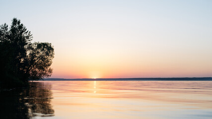 Naklejka na ściany i meble beautiful calm sunset on a large lake