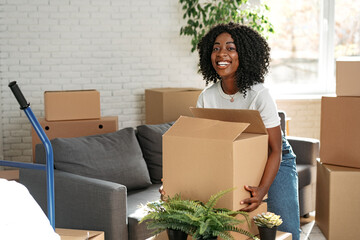 Happy african young woman with cardboard box moving to a new place