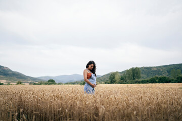 Pregnant young woman relaxing in wheat field