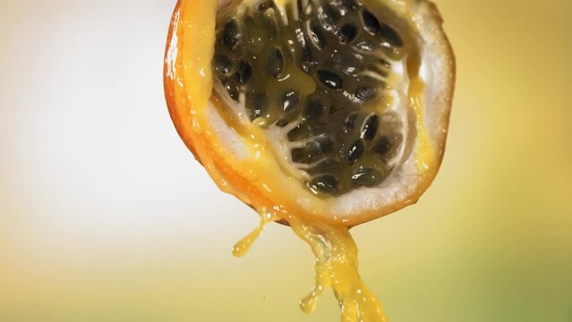 Slow Motion Macro Shot of Flowing Granadilla Juice from Halved Granadilla