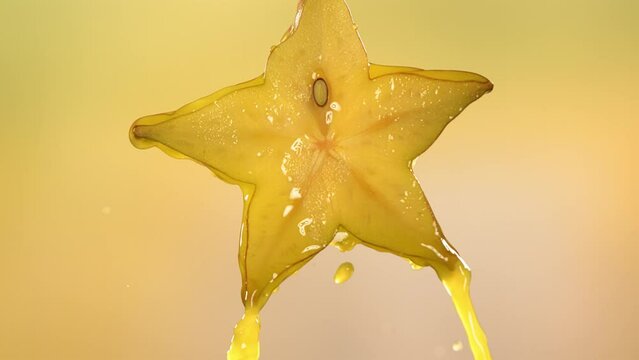 Slow Motion Macro Shot of Flowing Carambola Juice from Halved Carambola Star Fruit