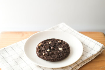 Large chocolate chip cookie on wooden table