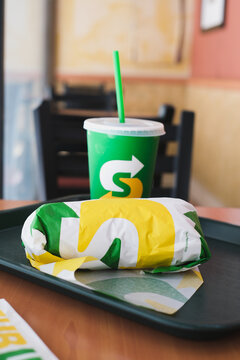 Bangkok, Thailand - December 5, 2022 : Sandwich Set on the tray warped in branded paper on wooden table at Subway Sandwich Restaurant
