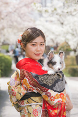 赤い振袖を着た女性と白毛の犬
