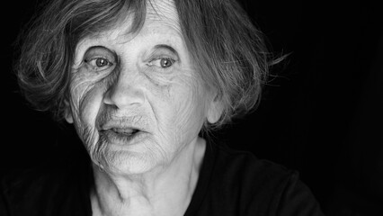 Portrait of senior caucasian woman talking on black background