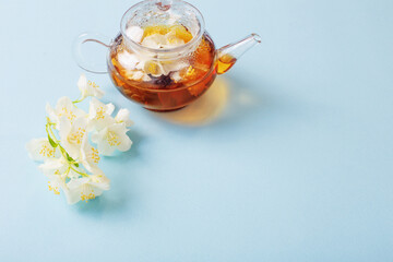 jasmine tea in glass teapot on blue background