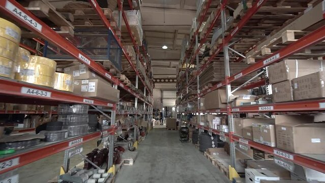 large factory warehouse. store aisles. The camera pans between shelves inside a large store. Delivery to the warehouse. Logistics business and forklift truck to move boxes and goods. freight mail