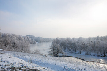 Obraz na płótnie Canvas A wonderful view of the frozen forest and the icy river in the high hill