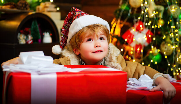Happy child near big gift. Christmas, New year kids. Funny kid with Christmas gift.