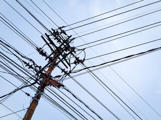 Electrical power junction at the pole reveals the complexity with the bright blue sky clouds