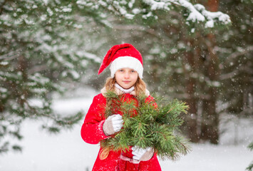 Portrait of a girl in a red coat in a winter forest