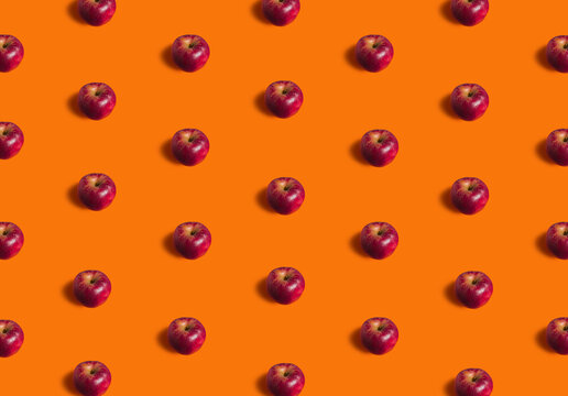 Fall flat lay pattern made with ripe apple fruit on orange background. Minimal concept with sowt shadows