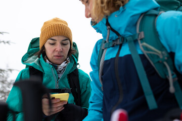 two tourists use the phone during the hike.