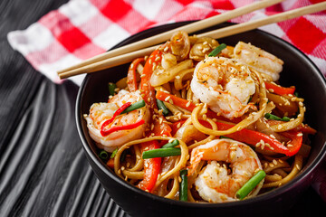 fried wok shrimp noodles on a black wooden rustic background
