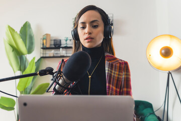 charming radio host girl broadcasting and using her laptop, medium shot radio and communication...