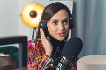 young and charming Latin-American woman working in a station and broadcasting news, medium closeup...
