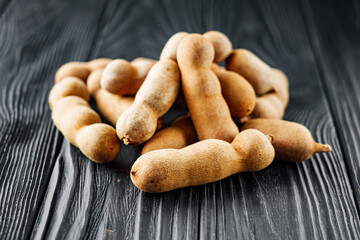 sweet and sour tamarind on a black rustic wooden background
