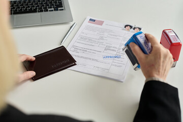 Close up of immigration office worker approving visa application for Caucasian young woman