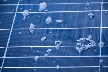The front surface of photovoltaic or solar cell panel which is wet with water and soap bubbles on...