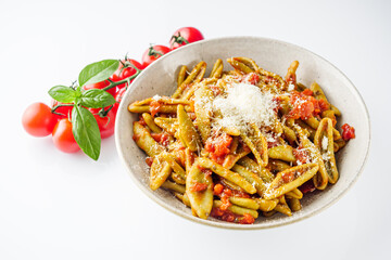 green cavatelli pasta with spinach in tomato sauce on a white background
