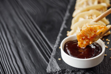 delicious fried gyoza dumplings on a black plate