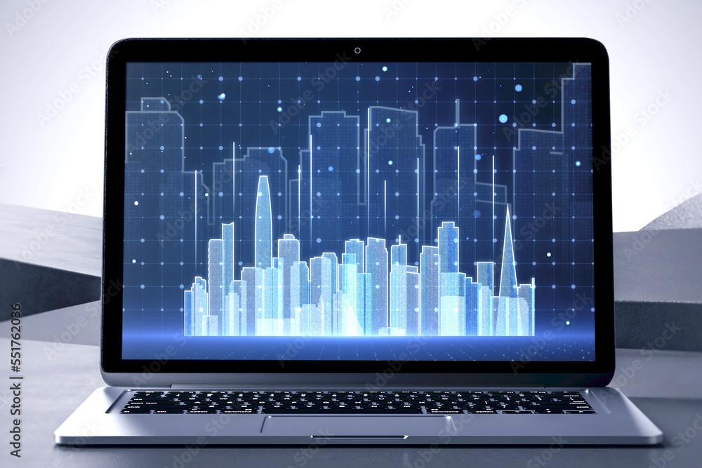 Poster close up of laptop computer screen at workpkace with abstract glowing city skyline hologram on blurr
