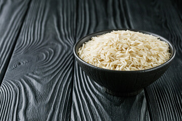 raw basmati rice on a black wooden background