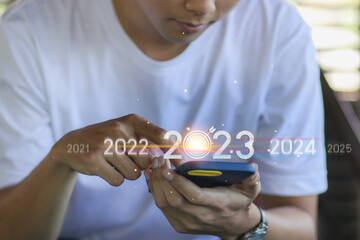 Trend of 2023. business investor using mobile phone with virtual 2023 year diagram, business trend,...