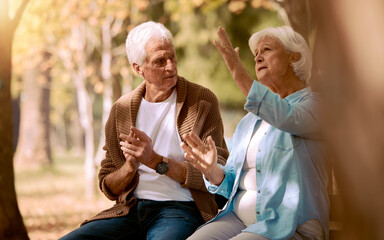 Senior couple, nature park and conversation for support, communication and relax in sunshine together. Elderly man, woman and sign language in garden, backyard and peace in retirement with disability