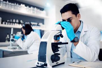 Science, research and man with medical microscope for exam, analysis and sample study in...