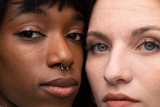 Very close portrait of the faces of two different ethnic girls