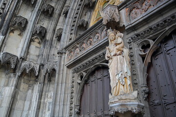 Close-up on the main entrance door to the Collegiale Notre Dame Church  in Dinant, Belgium, with carvings and statues