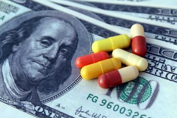 On a dollar bill are pills of a medicine capsule.