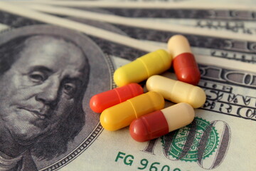 On a dollar bill are pills of a medicine capsule.