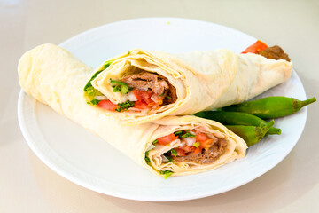 Grilled Turkish Adana, Urfa  Kebab with grilled vegetables, onion and rice on plate. Adana durum.