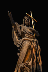 Ancient statues saint John, the Baptist against black background.