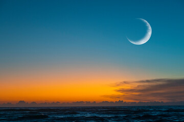 New moon or Сrescent above ocean. Half Moon on bright evening sky, space for text