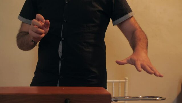 Musician playing unusual theremin instrument indoors using hand gestures, slowmotion