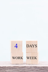 4 day working week words on wooden cube on blue background. reducing burnout and stress levels concept. copy space 