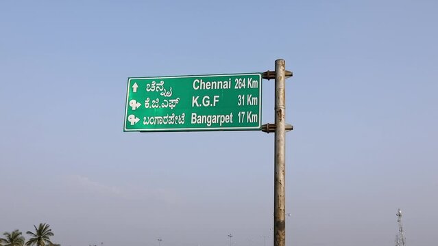 A closeup of green direction board on indian highways with distance