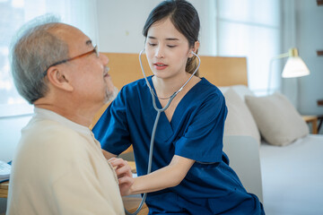 Nurse examines the stethoscope and checks the lungs of the heart of senior man in a nursing home.