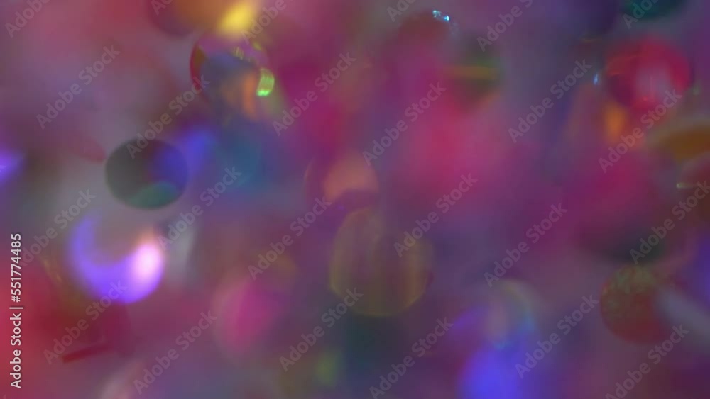 Wall mural natural multicolored metallic confetti particles float in a viscous liquid. glitter spangles and def