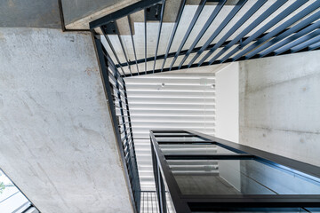 Perspective to modern concrete stairs with elevator shaft