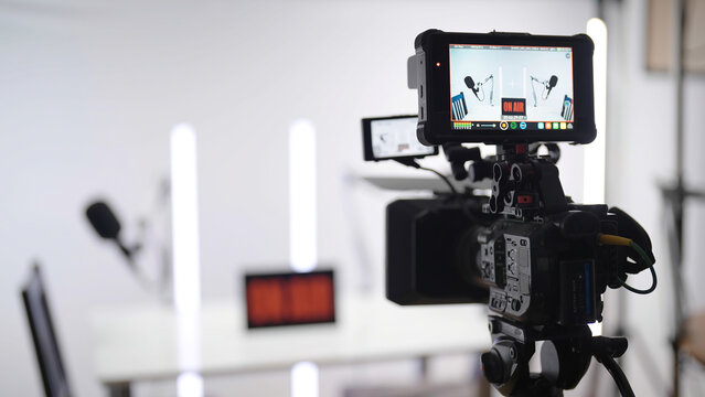 Professional camera recording podcast studio broadcasting on white background with white neon tubes