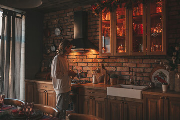 Portrait of candid authentic boy teenager holiday cooking in kitchen at wooden lodge Xmas decorated